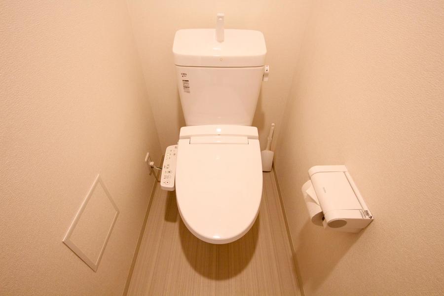 トイレは人気のウォシュレットタイプ。頭上には扉付きの収納棚が付いてます