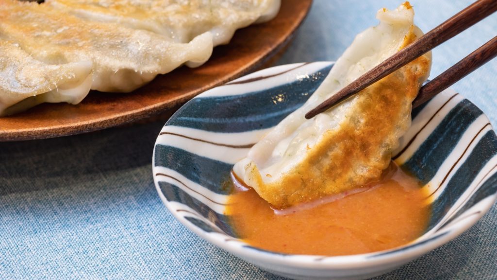 餃子を味噌だれにつける様子