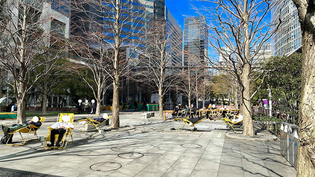 品川セントラルガーデンの椅子に座りリラックスするビジネスマンたち